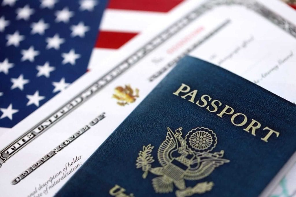 Certificado de Naturalización de EE. UU. con bandera estadounidense y pasaporte